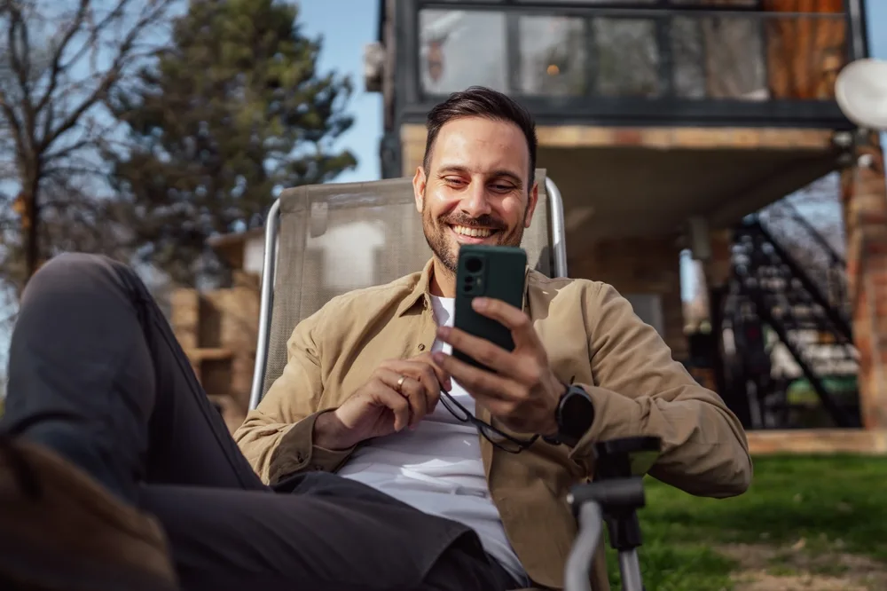 Довольный человек с телефоном в руке